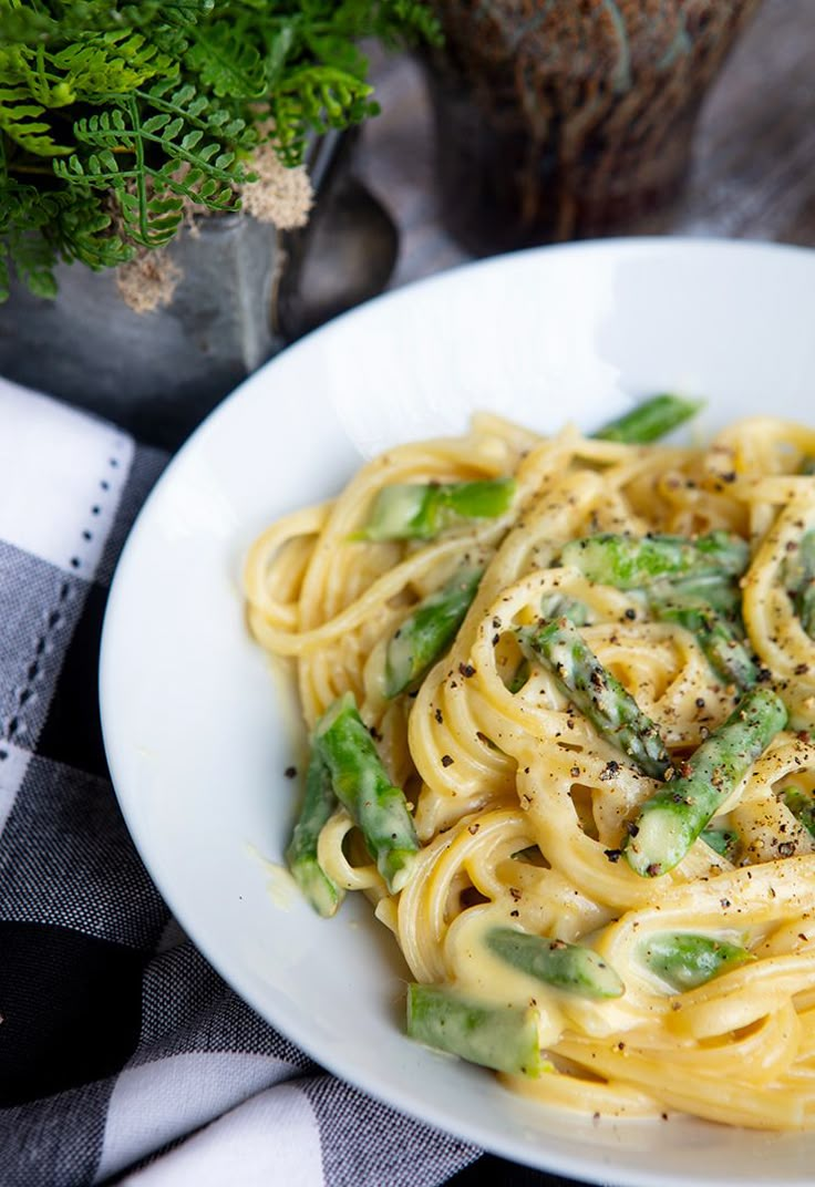 a white plate topped with pasta and asparagus