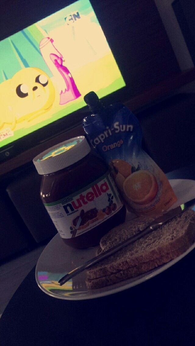 a plate with peanut butter, jelly and honey on it next to a flat screen tv