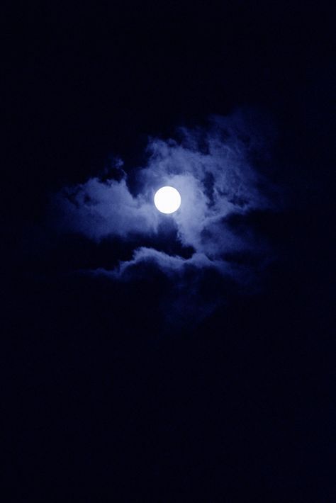 the full moon shines brightly in the dark night sky with clouds and blue hues