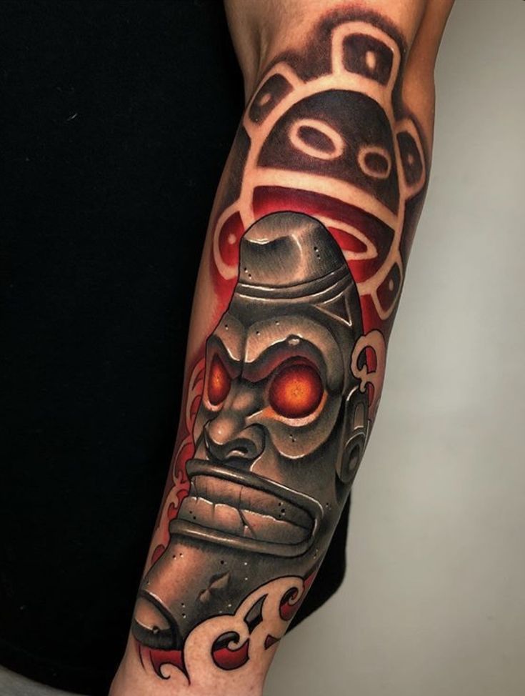 a man with a tattoo on his arm has a mask and flames in the background