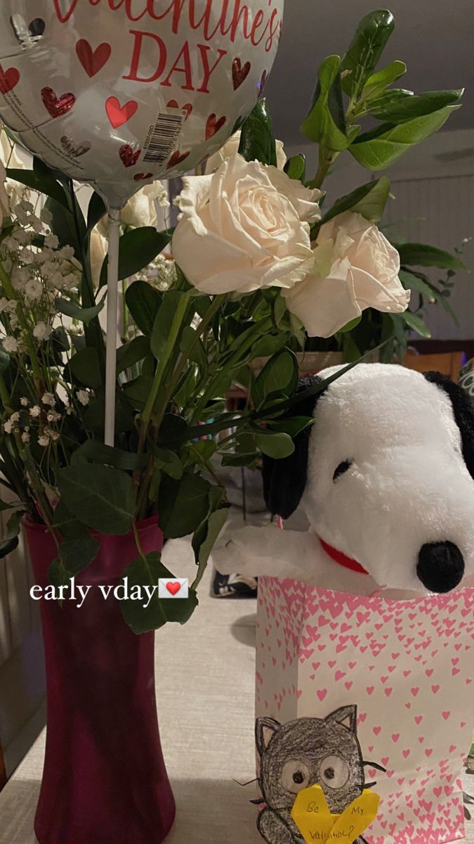 a stuffed dog is in a vase with flowers