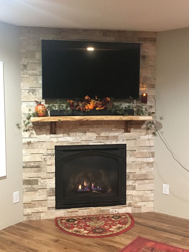 a fireplace with a flat screen tv above it and candles on the mantle next to it