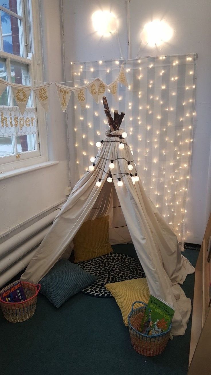 a teepee with lights hanging from it in a child's playroom area