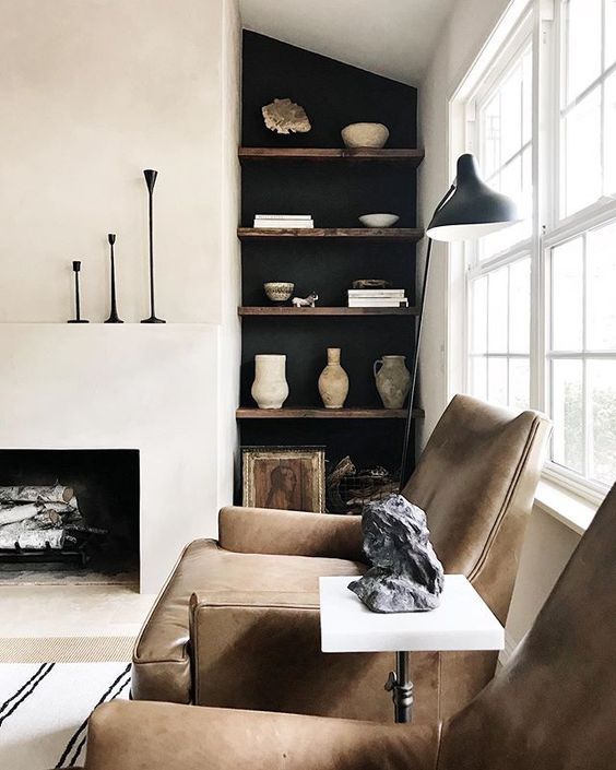 a living room filled with furniture and a fire place in front of a large window