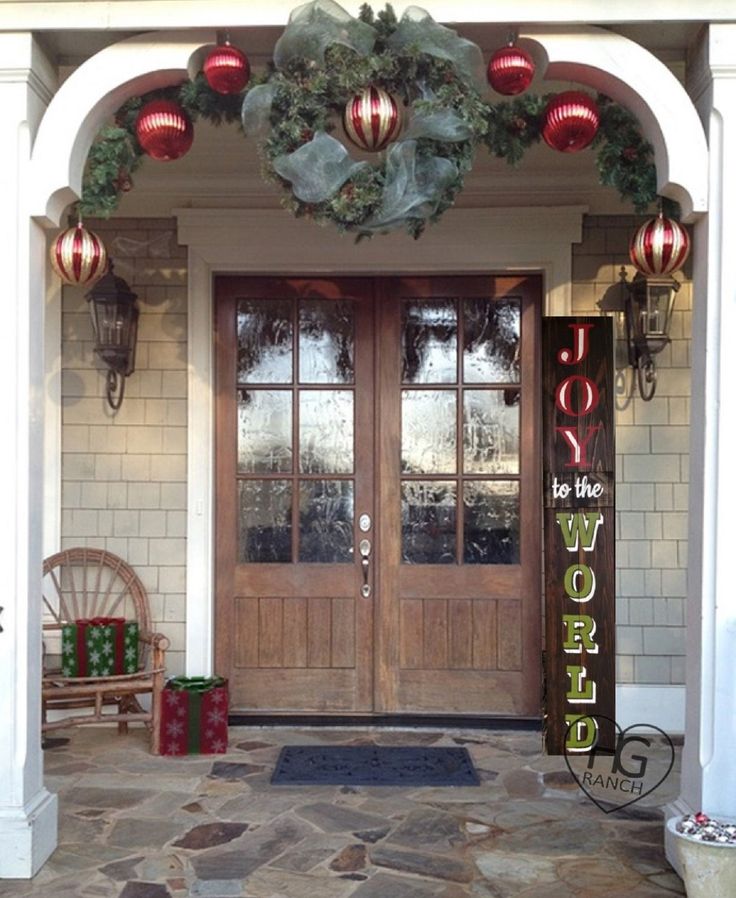 the front door is decorated for christmas with ornaments and wreaths hanging from it's sides