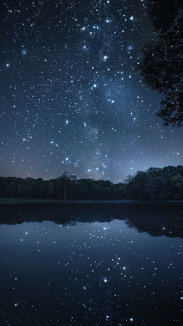 the night sky is filled with stars and reflecting in the still water on a lake