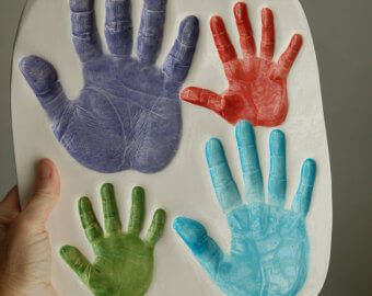 a person holding up a paper plate with handprints on it that says the grandpa's 2012