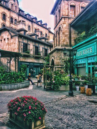 an old town square with flowers and buildings