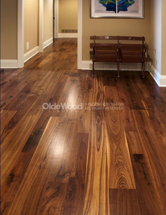 an empty hallway with wood floors and benches