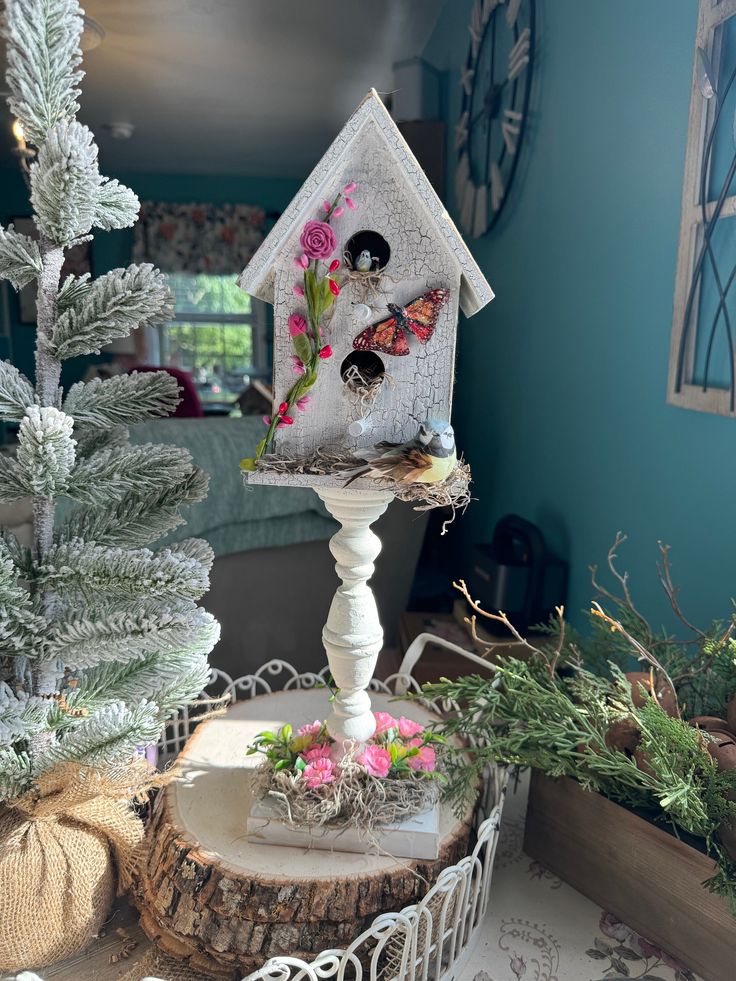 a white bird house sitting on top of a tree stump