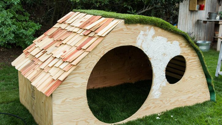 a dog house made out of wood and grass