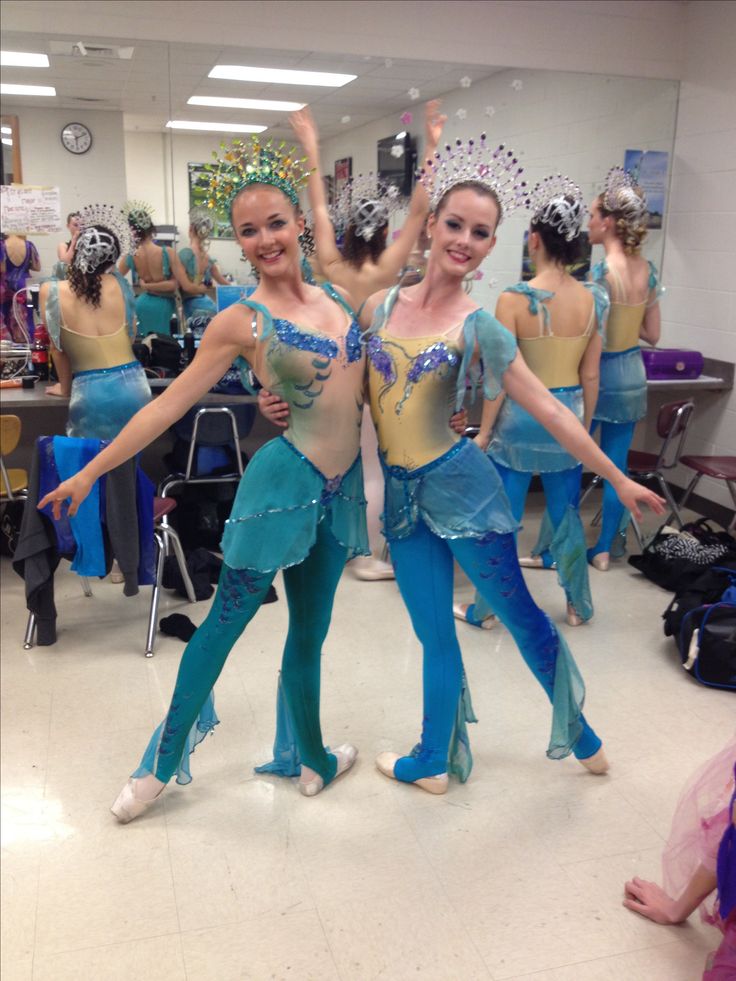 two women in blue and gold costumes are dancing