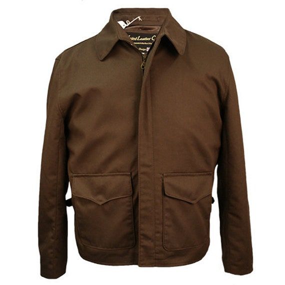 This jacket is our Cotton Raiders, a lightweight jacket perfect for casual-wear and those days where the leather version is just a bit too much. The jacket is taken from an altered version of the original movie pattern, so it fits the standard size charts and is a more comfortable jacket. The jacket itself sports a smaller and rounder collar than the Last Crusade and doesn't have the two press studs at the top and bottom of the collar. Standard Specifications: Two Way Pocket (hand warmers) Action Pleats for arm movement Side Vents One Inside pocket Facing & All Satin Lining Brass Zip & D-rings Each jacket is supplied with a Certificate of Authenticity Light weight jacket - perfect for Summer! Superior Mans Weight Poly Cotton Twill Made in England Fall Solid Collared Sport Coat, Classic Solid Utility Jacket With Welt Pockets, Military Cotton Outerwear With Lapel Collar, Military Style Cotton Outerwear With Lapel Collar, Classic Collared Outerwear With Zip Fly, Brown Cotton Outerwear With Patch Pockets, Military Style Outerwear With Lapel Collar And Pockets, Fall Sport Coat With Pockets And Stand Collar, Brown Outerwear With Zip Fly For Work