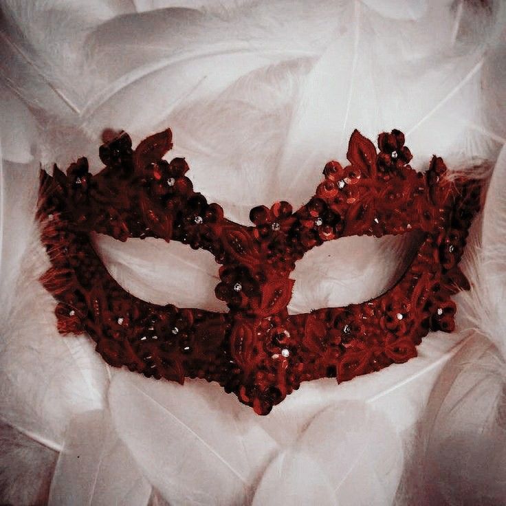 a red mask with feathers on it