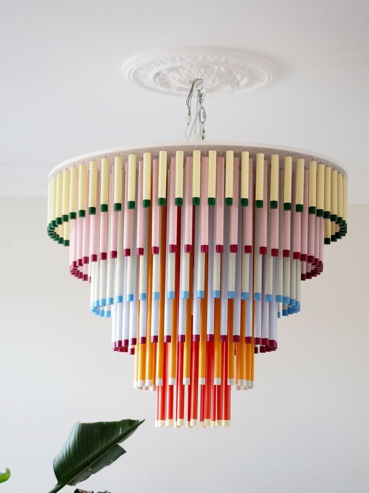 a multicolored chandelier hanging from a ceiling in a room with white walls