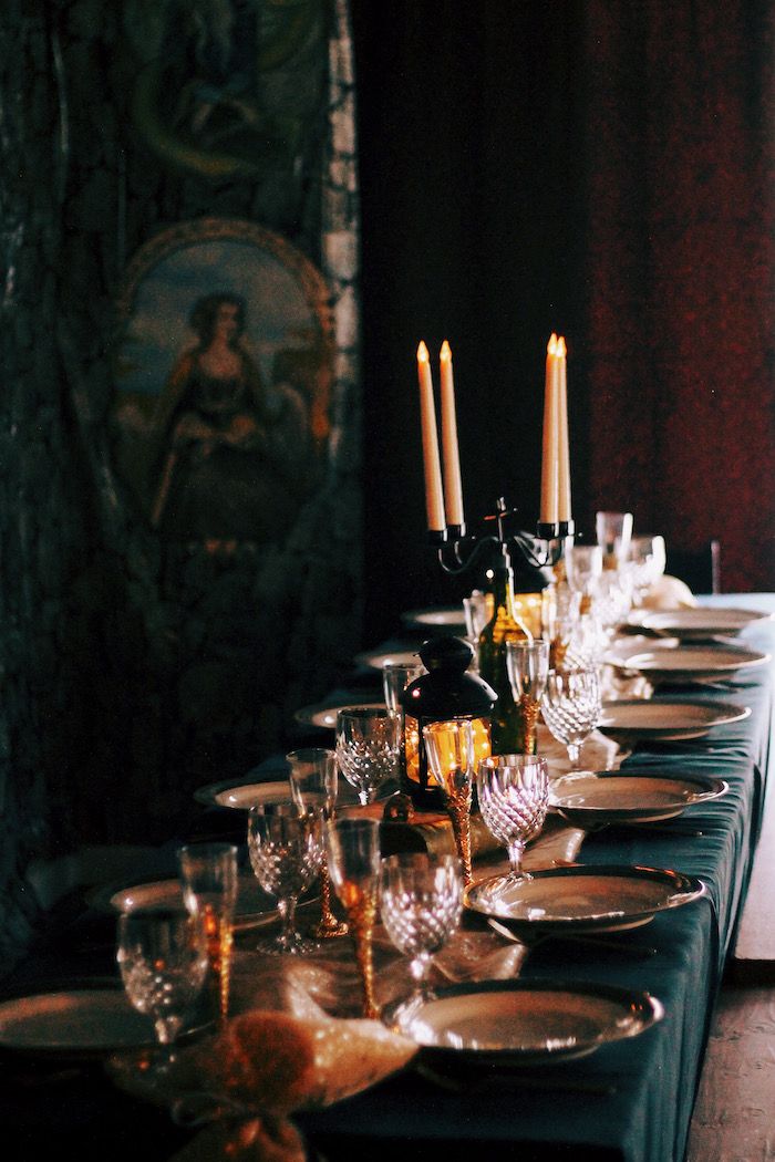 a long table is set with wine glasses and candles