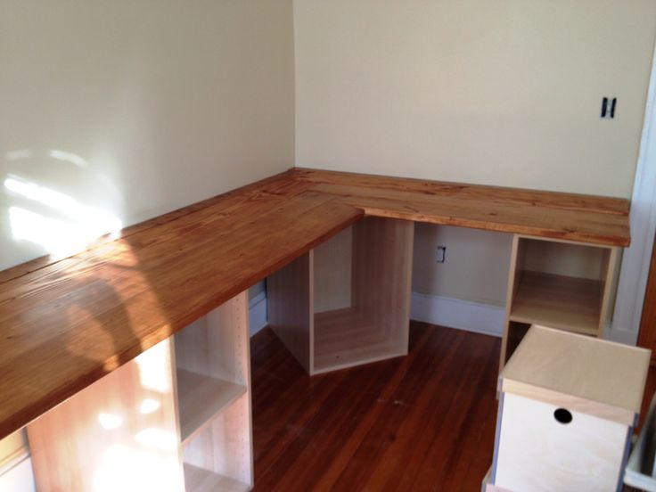 an empty room with wood floors and shelves on the wall, next to a window