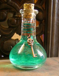 a green glass bottle with a key hanging from it