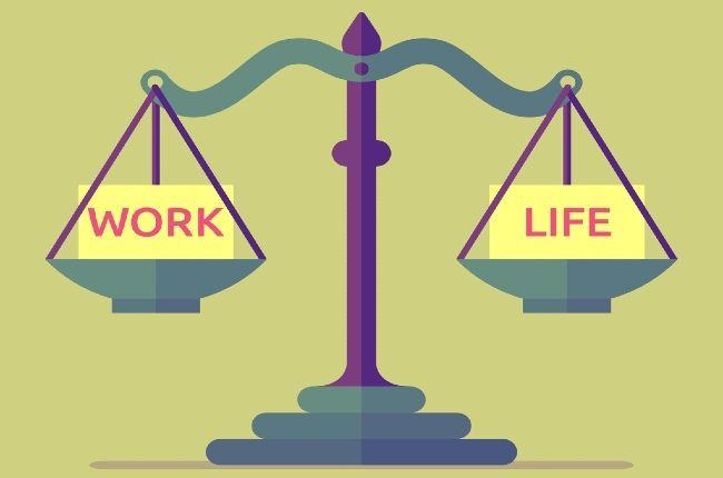 two signs that say work and life sitting on top of a balance scale in front of a green background