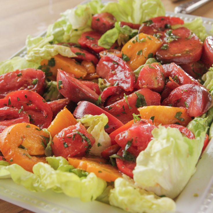 a salad with tomatoes, lettuce and other veggies is shown on a plate