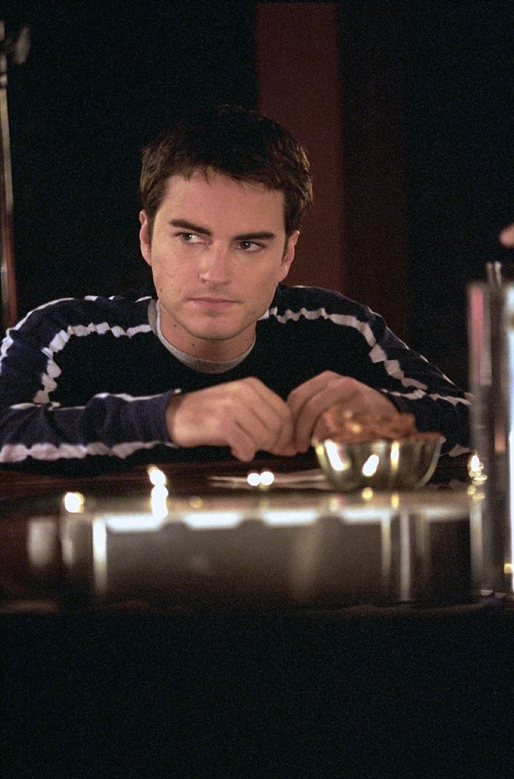 a man sitting at a table in front of a candle