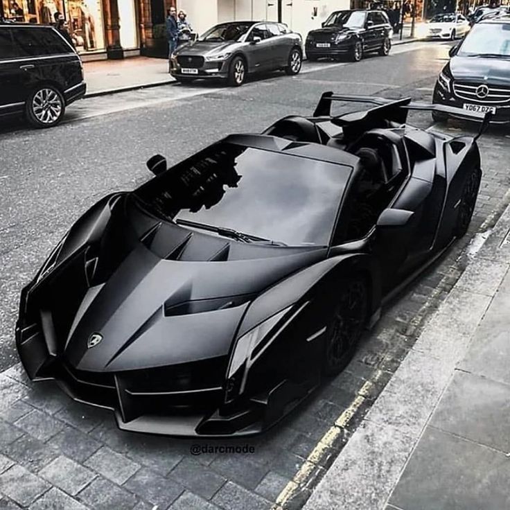 a black sports car is parked on the street