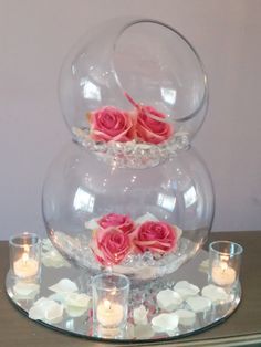 three tiered glass vases with pink flowers in them