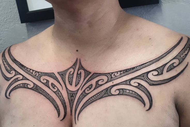 a man with a chest tattoo that has an intricate design on it's chest