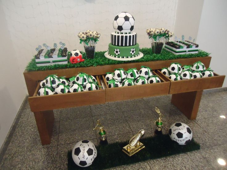 a table topped with soccer themed cakes and cupcakes