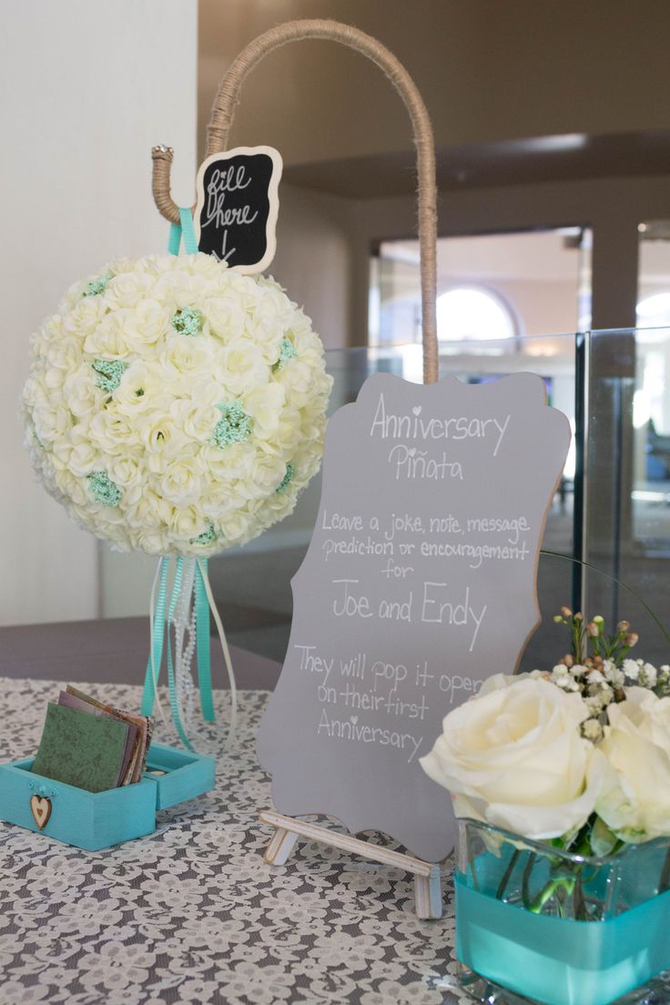 the table is set up with flowers and cards for guests to write their names on