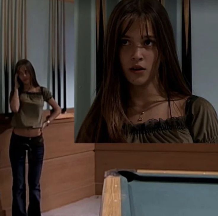 two young women are standing in front of a pool table and one is looking at the camera