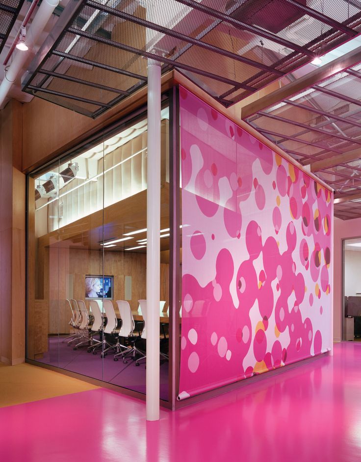 an office with pink walls and white chairs