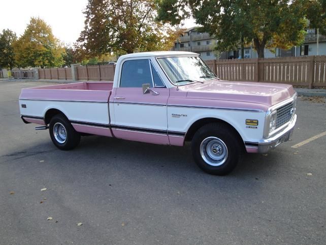 a pink and white truck parked in a parking lot