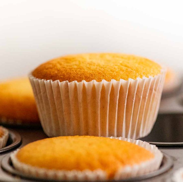 two muffins sitting on top of each other in front of some cupcake tins