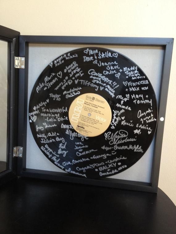 a black record with writing on it in a shadow box next to a glass case