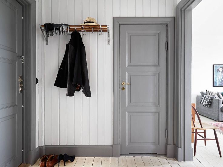 an open door and coat rack in a white room