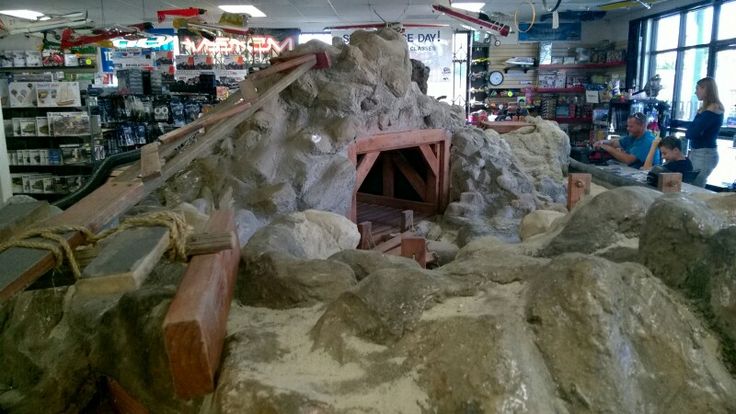 a large pile of rocks in a store with people looking at them through the window