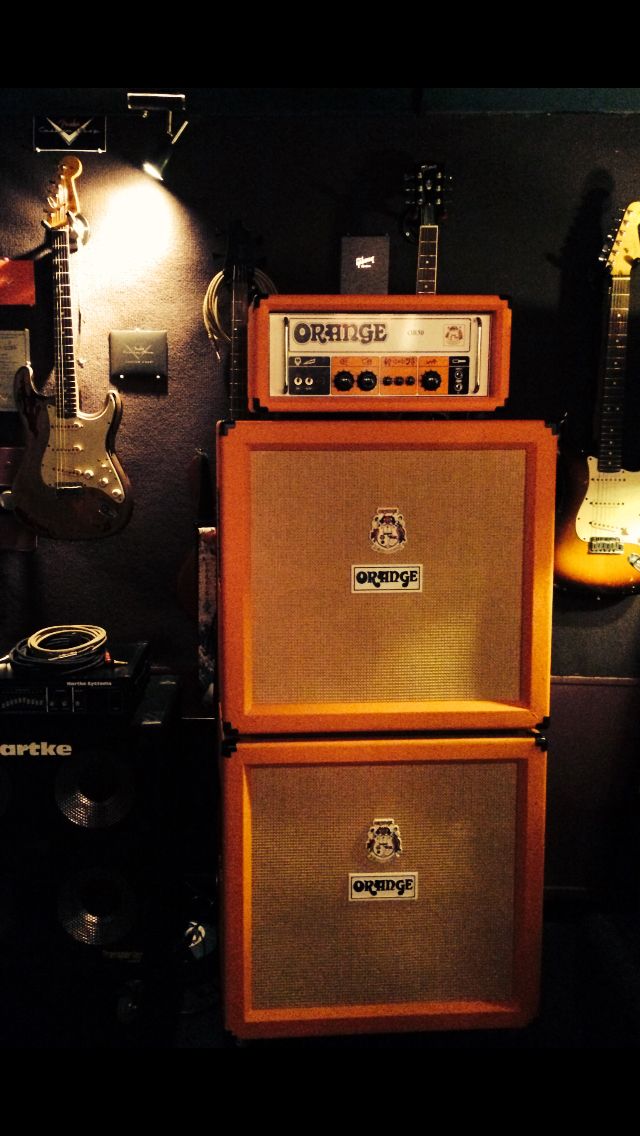 two guitars and amps are on display in a room with other musical equipment,