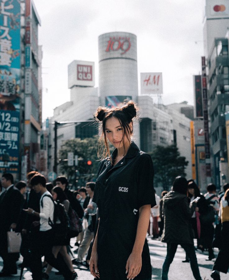 a woman standing in the middle of a busy city street wearing an instagram t - shirt