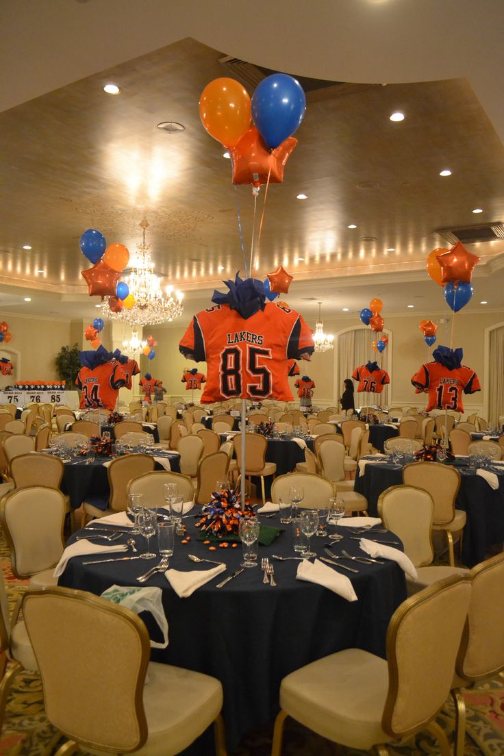 an indoor banquet hall decorated with balloons and sports jerseys