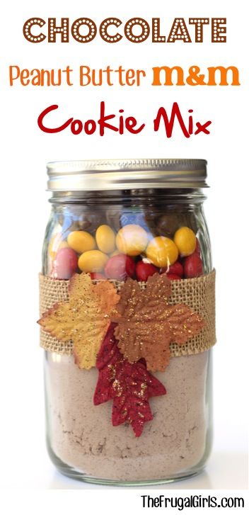 a jar filled with cookies and candies on top of a table next to a sign that says chocolate peanut butter m & m cookie mix