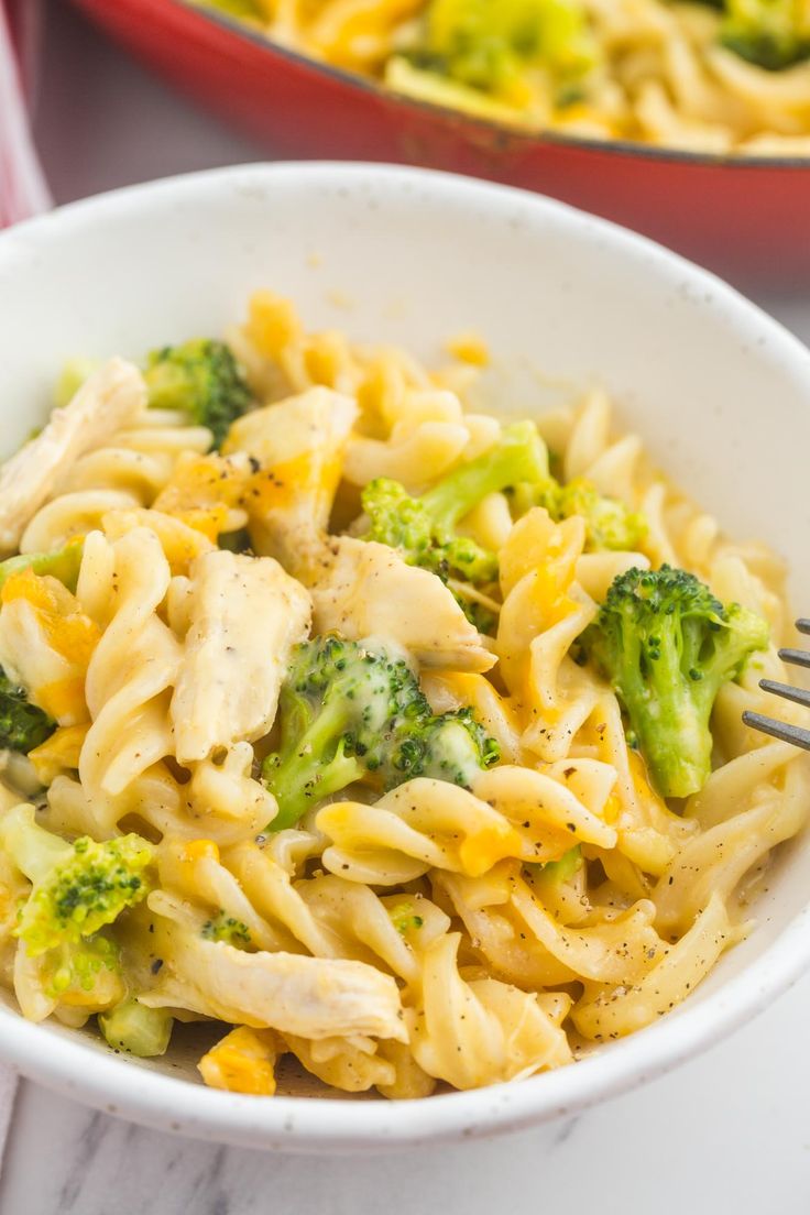 a white bowl filled with pasta and broccoli