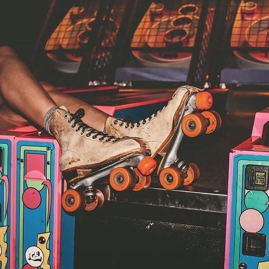 a person sitting on top of a skateboard in front of two colorful boxes with wheels