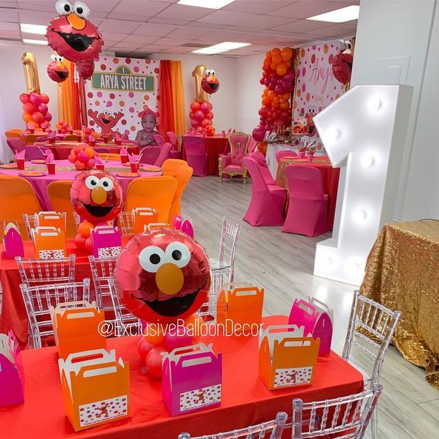 the sesame street birthday party is set up with pink and orange decorations