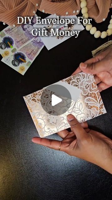 two hands are holding an envelope with money on it and the words diy envelope for gift