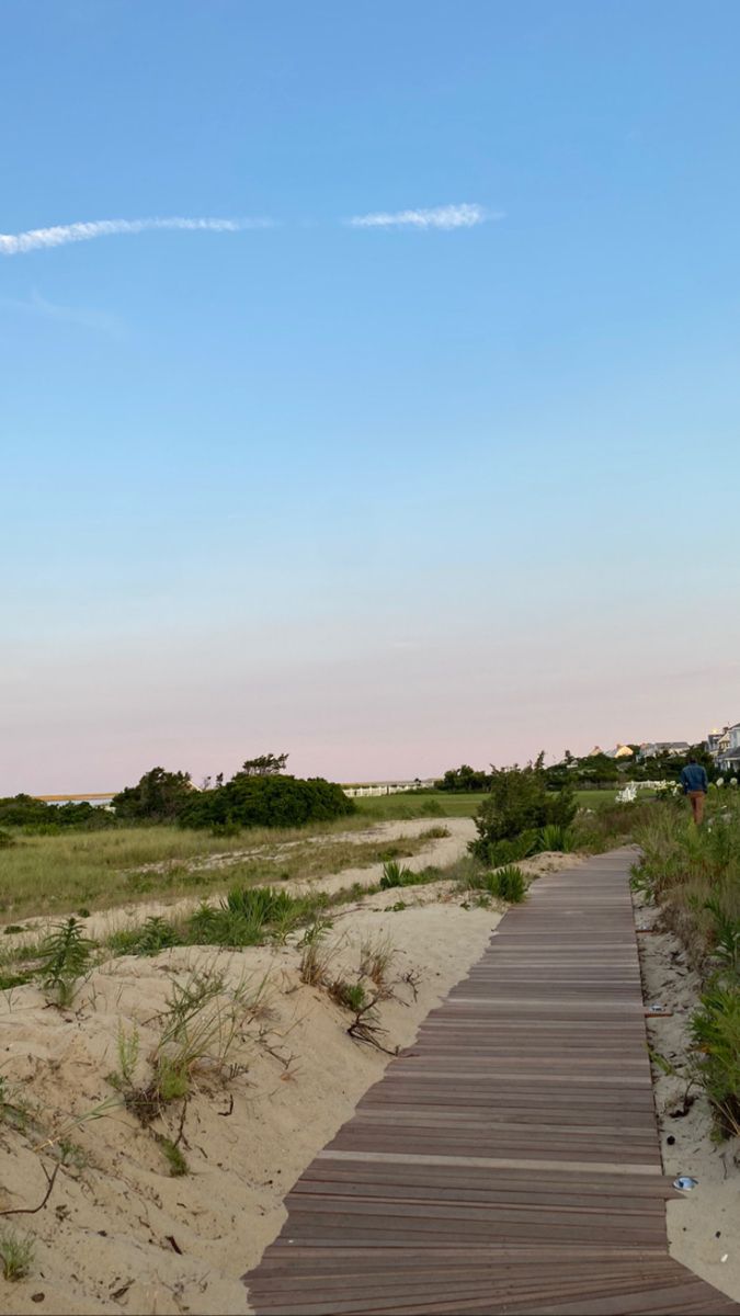 there is a wooden walkway going to the beach