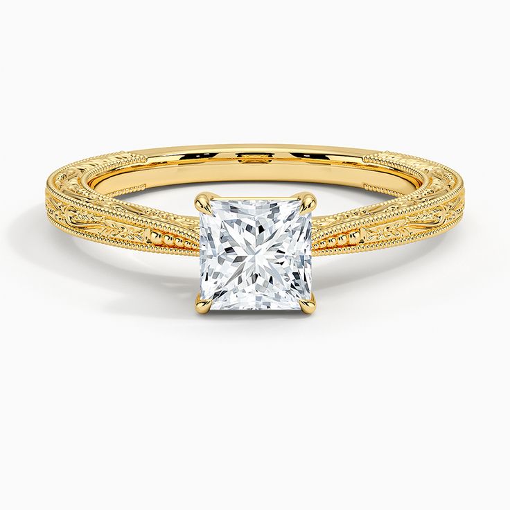 a yellow gold engagement ring with a princess cut diamond in the center and filigree band