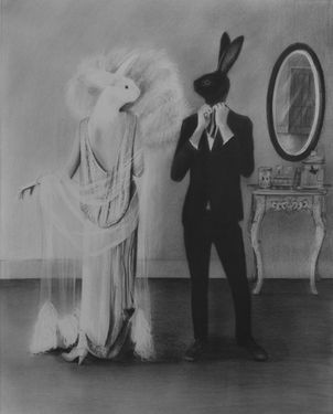 a black and white photo of a man standing next to a woman in bunny ears