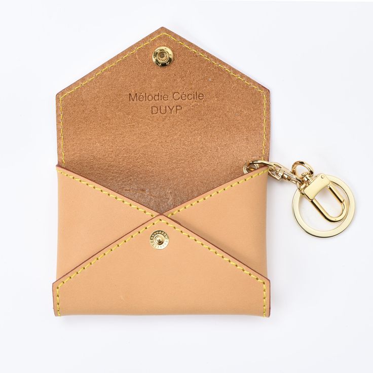 a card case with a keychain attached to it and a leather tag hanging from the front