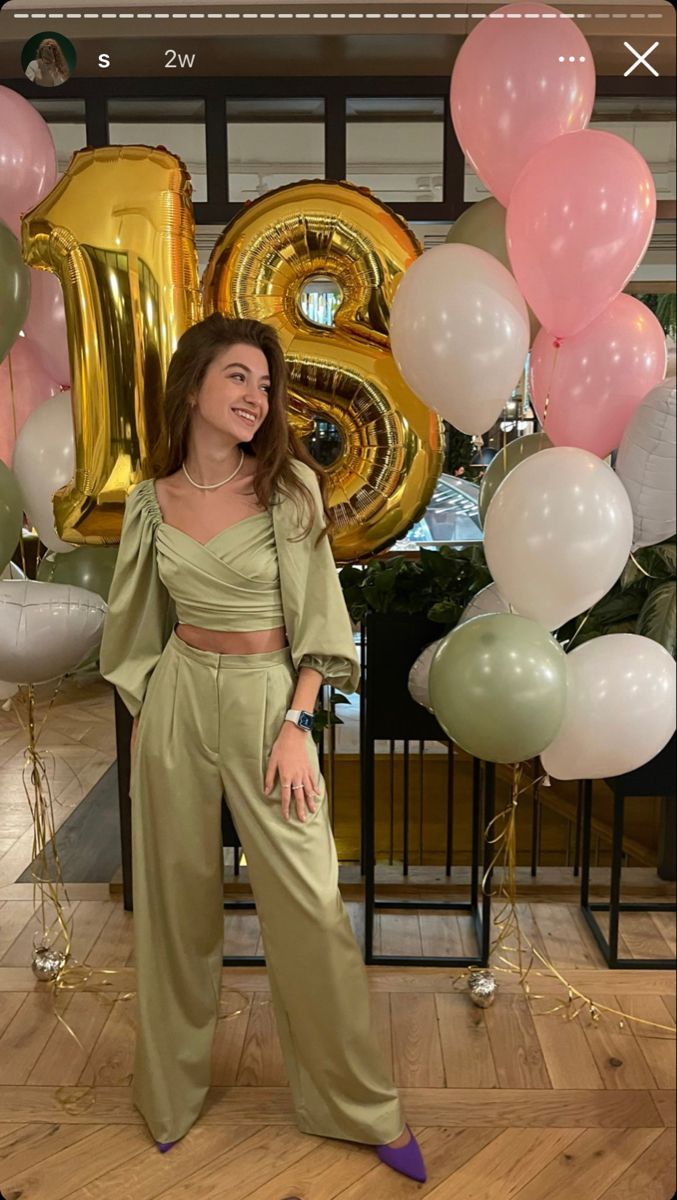 a woman standing in front of balloons and numbers